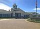 Community clubhouse with a charming clock tower, well-manicured landscaping, and a brick-paved driveway at 523 Eastern Isle Ave, Summerville, SC 29486