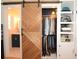 Closet features a sliding barn door, built-in shelving, rods and hanging clothes, and a view into the bathroom at 5273 Potomac St, North Charleston, SC 29405