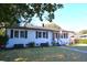 Charming white brick home with black shutters, an American flag, and well-manicured lawn at 5273 Potomac St, North Charleston, SC 29405