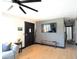 Cozy living room featuring a brick accent wall with TV, a dark wooden door, and hardwood floors at 5273 Potomac St, North Charleston, SC 29405