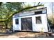 Exterior of the modern white shed with black trim and double doors in the backyard at 5273 Potomac St, North Charleston, SC 29405