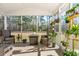 Screened-in sunroom featuring wicker furniture and a view of the wooded yard at 573 Yellow Leaf Ln, Summerville, SC 29486