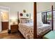 Bedroom with a four poster bed, hardwood floors, and access to a private balcony, creating a tranquil retreat at 601 Magnolia Ln, Edisto Island, SC 29438