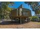 Unique home design elevated on stilts, featuring a balcony and surrounded by trees at 601 Magnolia Ln, Edisto Island, SC 29438