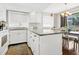 Bright kitchen featuring white cabinets, granite countertops, stainless steel appliances, and a dining area at 601 Magnolia Ln, Edisto Island, SC 29438