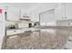 Modern kitchen boasts granite countertops, white cabinets, stainless appliances, and a stylish mosaic backsplash at 601 Magnolia Ln, Edisto Island, SC 29438