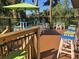 Inviting outdoor patio area with tables, chairs, and umbrellas surrounded by lush landscaping at 601 Magnolia Ln, Edisto Island, SC 29438