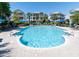 Sparkling community pool surrounded by lounge chairs and umbrellas for relaxation at 601 Magnolia Ln, Edisto Island, SC 29438