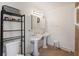 Bright bathroom featuring a double vanity with pedestal sinks, ample lighting, and neutral tile floor at 680 Kent St, Mount Pleasant, SC 29464