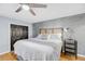 Bedroom featuring a ceiling fan, wooden floors, closet, stylish accent wall, and glass topped bedside table at 8 Townpark Ln # B, Charleston, SC 29412