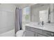 Bright bathroom features a shower-tub combo, gray vanity, and large mirror at 808 S Pointe Blvd, Summerville, SC 29483