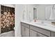Well-lit bathroom featuring a double sink vanity and decorative floral shower curtain at 808 S Pointe Blvd, Summerville, SC 29483