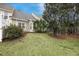Lush backyard with green grass and mature trees creating a serene outdoor space at 8618 Grassy Oak Trl, North Charleston, SC 29420