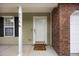 Inviting front entrance with brick accents, white door, and welcoming porch at 8618 Grassy Oak Trl, North Charleston, SC 29420