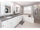 Bright bathroom with double vanity, granite counters, and tiled shower and tub at 8745 Alexandria Dr, North Charleston, SC 29420
