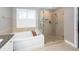 Modern bathroom featuring a glass shower and large soaking tub at 8745 Alexandria Dr, North Charleston, SC 29420
