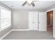Bedroom with carpet, ceiling fan, and window; closet doors and entry door are visible at 8745 Alexandria Dr, North Charleston, SC 29420