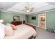 Bedroom with a view into the ensuite bath, and a tray ceiling and fan at 8745 Alexandria Dr, North Charleston, SC 29420