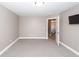 Bedroom with neutral carpet, light gray walls, a ceiling light, an open door, and a TV on the wall at 8745 Alexandria Dr, North Charleston, SC 29420