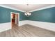 Formal dining room featuring wainscoting, wood-look floors, and a modern chandelier at 8745 Alexandria Dr, North Charleston, SC 29420