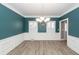 Dining room features wainscoting, wood-look floors, modern chandelier, and shuttered windows at 8745 Alexandria Dr, North Charleston, SC 29420