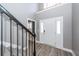 Bright foyer with soaring ceilings, wood-look flooring, and staircase with black metal railings at 8745 Alexandria Dr, North Charleston, SC 29420