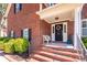 Inviting front entrance featuring brick steps, a wreath-adorned door, and a cozy bench at 8745 Alexandria Dr, North Charleston, SC 29420