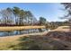 Scenic view of a calm pond reflecting the surrounding trees, providing a peaceful environment at 8745 Alexandria Dr, North Charleston, SC 29420