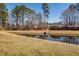 Picturesque view of a serene pond with mature trees, creating a tranquil natural setting at 8745 Alexandria Dr, North Charleston, SC 29420