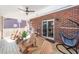 Covered porch with wood flooring, outdoor seating, ceiling fan, and brick wall, perfect for relaxation and entertaining at 8745 Alexandria Dr, North Charleston, SC 29420