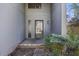 An exterior view of a front door with a storm door, a hanging light, and flowering bushes near the entrance at 9 Stallion Ct, Charleston, SC 29407
