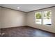 A serene bedroom bathed in natural light with two large windows and dark vinyl floors at 116 Wisteria Falls Trl, Saint Stephen, SC 29479