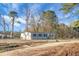 Charming single-story home with gray siding, complemented by a large yard and a backdrop of mature trees at 116 Wisteria Falls Trl, Saint Stephen, SC 29479