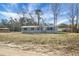 Inviting single-story home with gray siding and black shutters, surrounded by a spacious yard ready for landscaping at 116 Wisteria Falls Trl, Saint Stephen, SC 29479