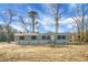 Well-maintained single-story home featuring gray siding, black shutters and a welcoming entryway, nestled in nature at 116 Wisteria Falls Trl, Saint Stephen, SC 29479