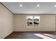An empty living room with wood-look flooring, bright windows, and recessed lighting at 116 Wisteria Falls Trl, Saint Stephen, SC 29479
