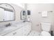 Bathroom features dual sinks with marble counters, modern fixtures, arched mirrors and black and white tile flooring at 129 Grand Pavilion Blvd, Isle of Palms, SC 29451