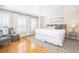 Bright bedroom with hardwood floors, a king bed, soft rug, and plenty of natural light from windows with shutters at 129 Grand Pavilion Blvd, Isle of Palms, SC 29451