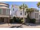 Beautiful three-story beach house featuring covered parking, lush landscaping and inviting entrance at 129 Grand Pavilion Blvd, Isle of Palms, SC 29451