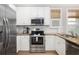 Bright kitchen featuring stainless steel appliances, white cabinets, and granite countertops, perfect for cooking and entertaining at 129 Grand Pavilion Blvd, Isle of Palms, SC 29451