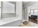 Bright main bathroom features a tub, frosted window for privacy, and a glass shower enclosure at 138 Back Tee Cir, Summerville, SC 29485