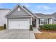 Charming exterior of a gray, one-story home with a two-car garage and well-maintained landscaping at 139 Ancestry Ln, Moncks Corner, SC 29461