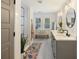 Bright bathroom with a glass shower, patterned rug, and large vanity with dual sinks at 1605 Evergreen St, Charleston, SC 29407