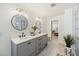 Bathroom with dual sinks, stylish mirrors, and a glass shower visible through an open doorway at 1605 Evergreen St, Charleston, SC 29407