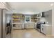 Modern kitchen featuring stainless steel appliances, sleek countertops, and floating wooden shelves for storage at 1605 Evergreen St, Charleston, SC 29407