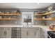 Modern kitchen features stainless steel appliances, herringbone backsplash, and open wood shelving at 1605 Evergreen St, Charleston, SC 29407