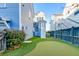 Backyard view showcases a putting green bordered by lush landscaping between neighboring houses at 1625 Oak Leaf St, Daniel Island, SC 29492
