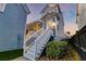 View of backyard with a raised screened in porch and white stairs at 1625 Oak Leaf St, Daniel Island, SC 29492