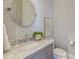 Well-lit powder room with marble countertop, stylish mirror, and neutral decor at 1625 Oak Leaf St, Daniel Island, SC 29492
