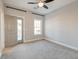 Neutral bedroom with a ceiling fan, carpeted floor, and access to the outside balcony at 1625 Oak Leaf St, Daniel Island, SC 29492